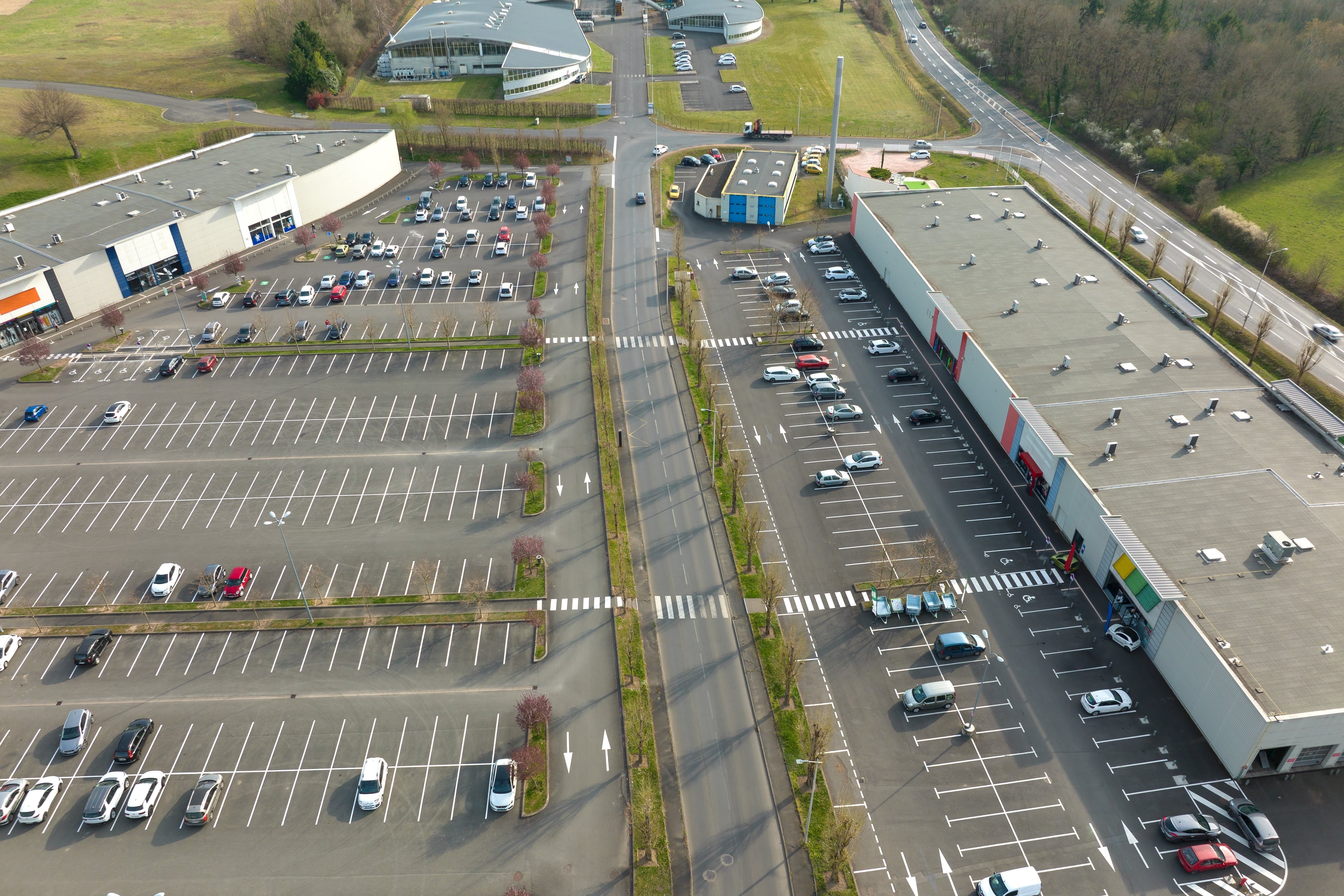 Aerial image of a mostly vacant parking lot in a strip mall