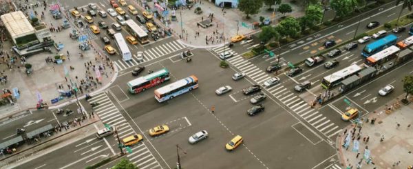 Aerial view of a large intersection with cars, buses, bicycles, and pedestrians