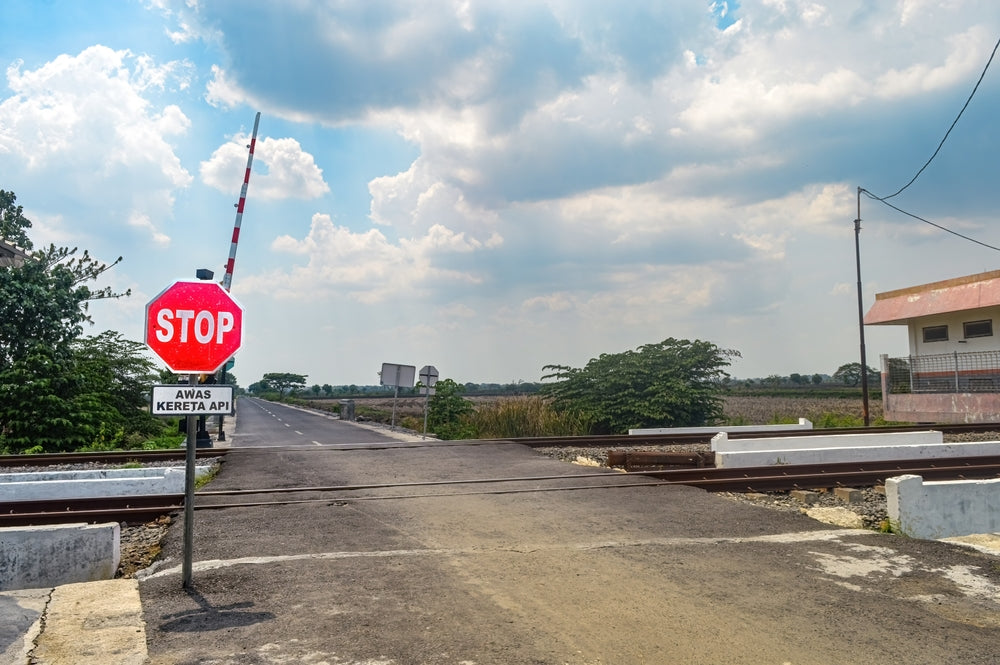 At grade railroad crossing with stop sign and train actuated stop bar arm raised