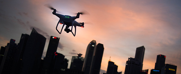 Drone flying in front of a city skyscape during sunset