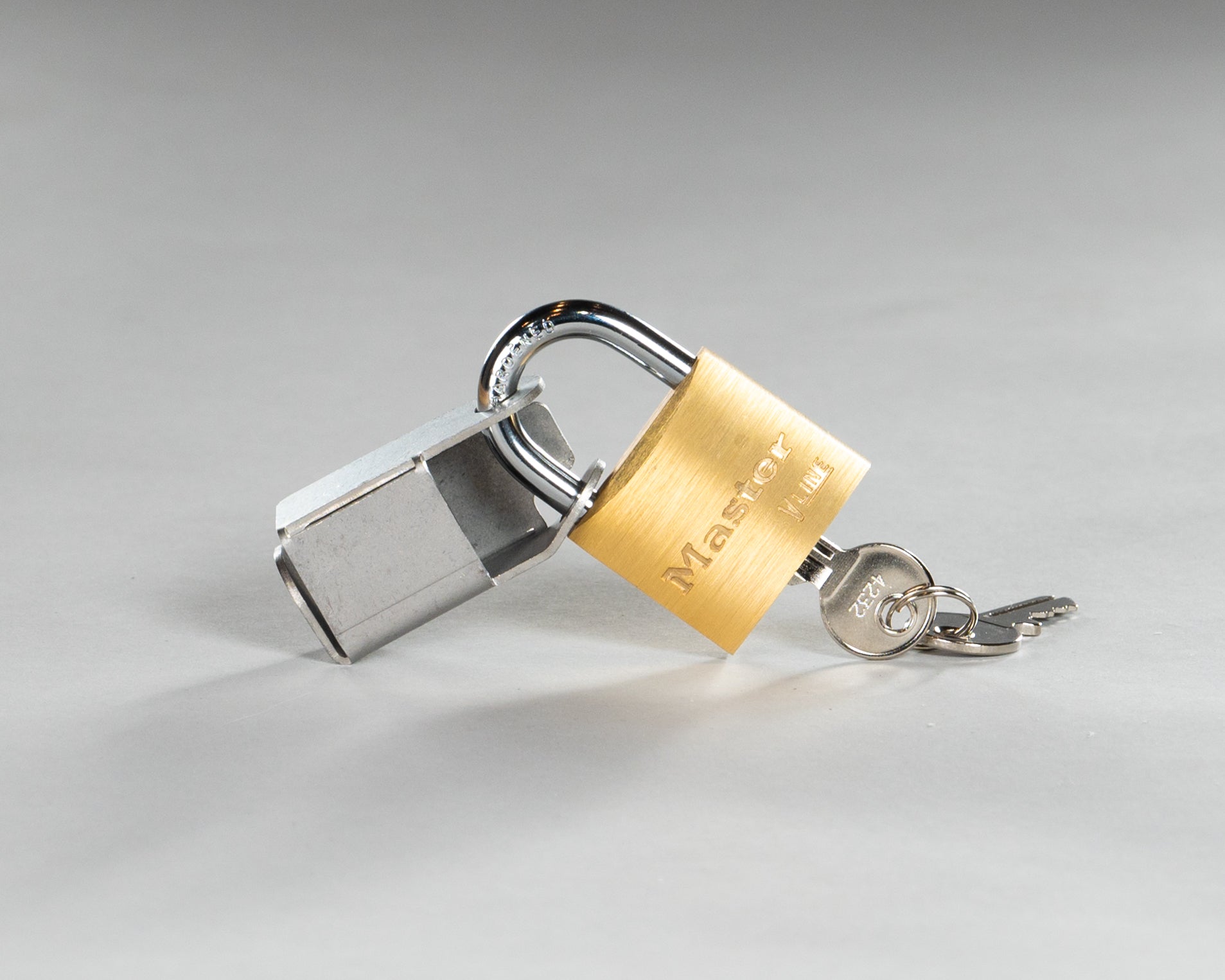 Gold padlock attached to lock bracket with keys