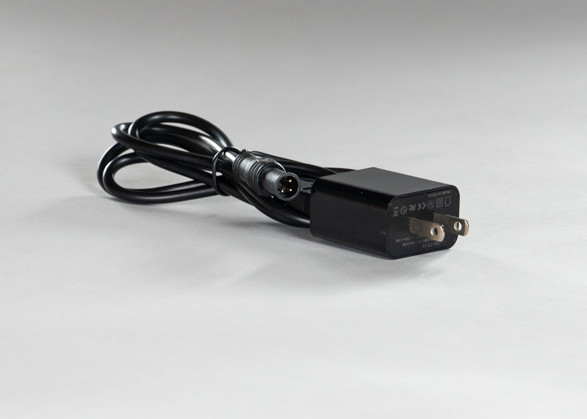 Black countCAM charging cable with outlet based tightly coiled and fastened with twist tie